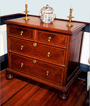 Diminutive inlaid chest of drawers on ball feet