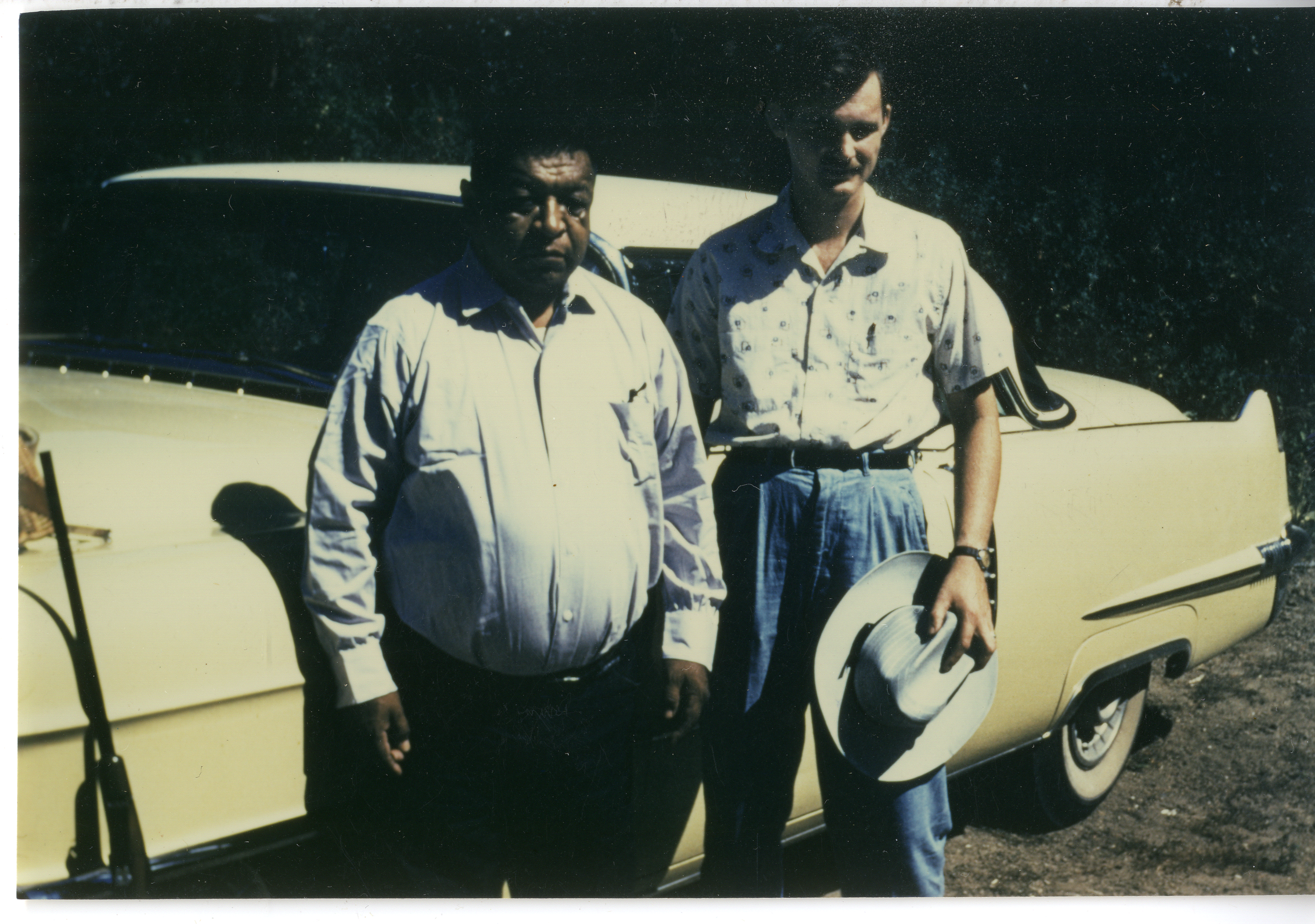 photo of two men in front of car