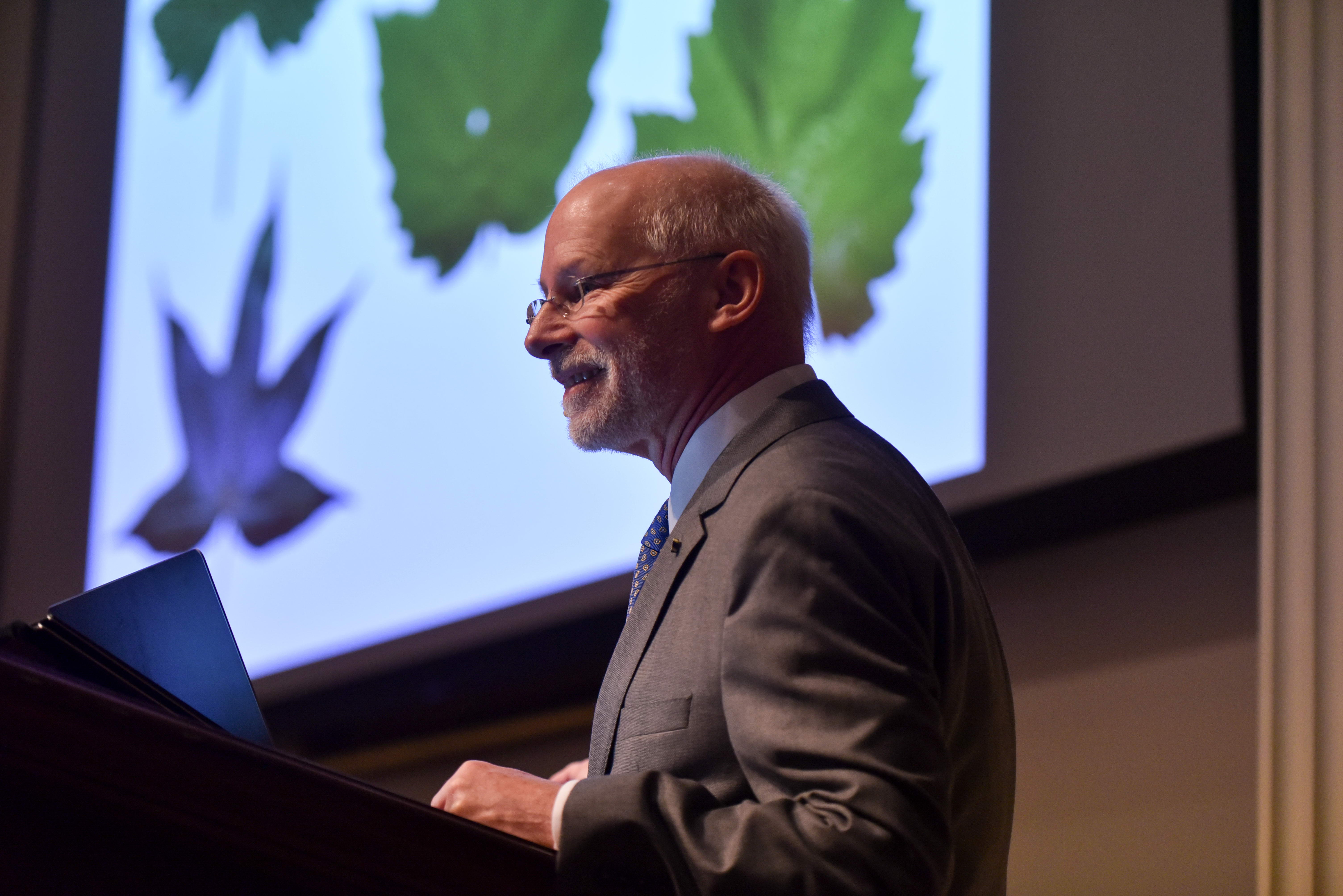 man in front of screen projecting image of leaves