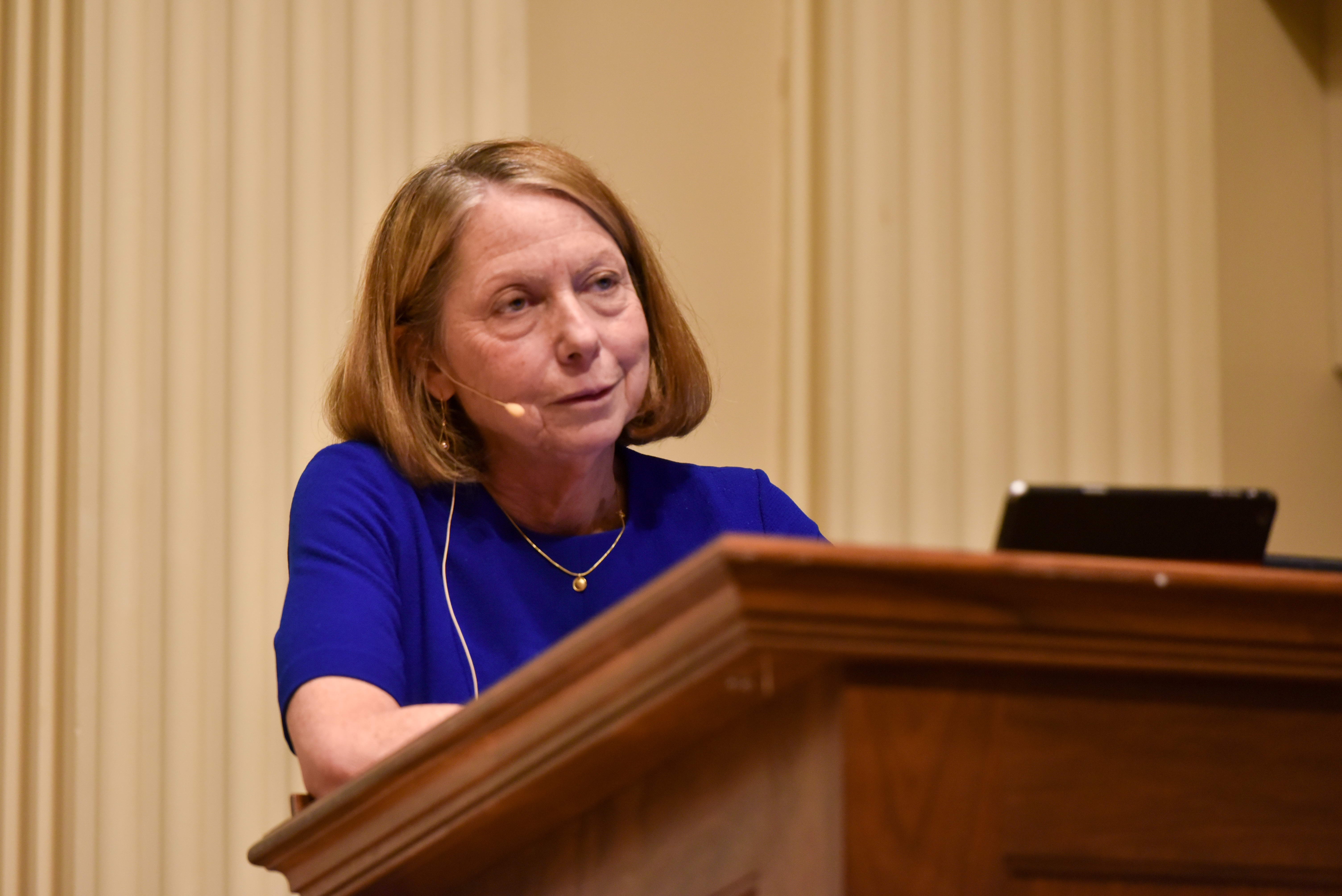 woman in blue dress at podium