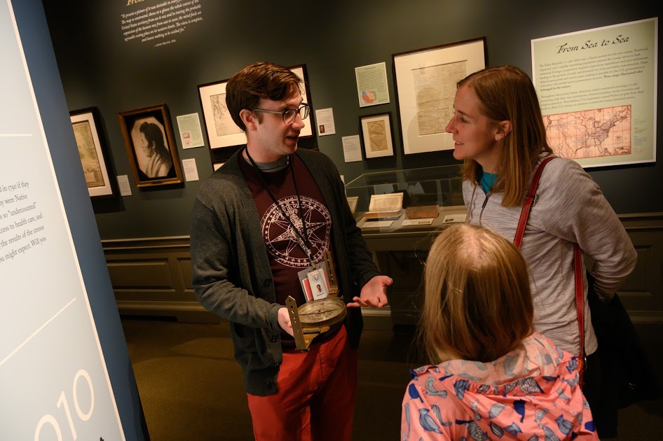 man talking with family in museum