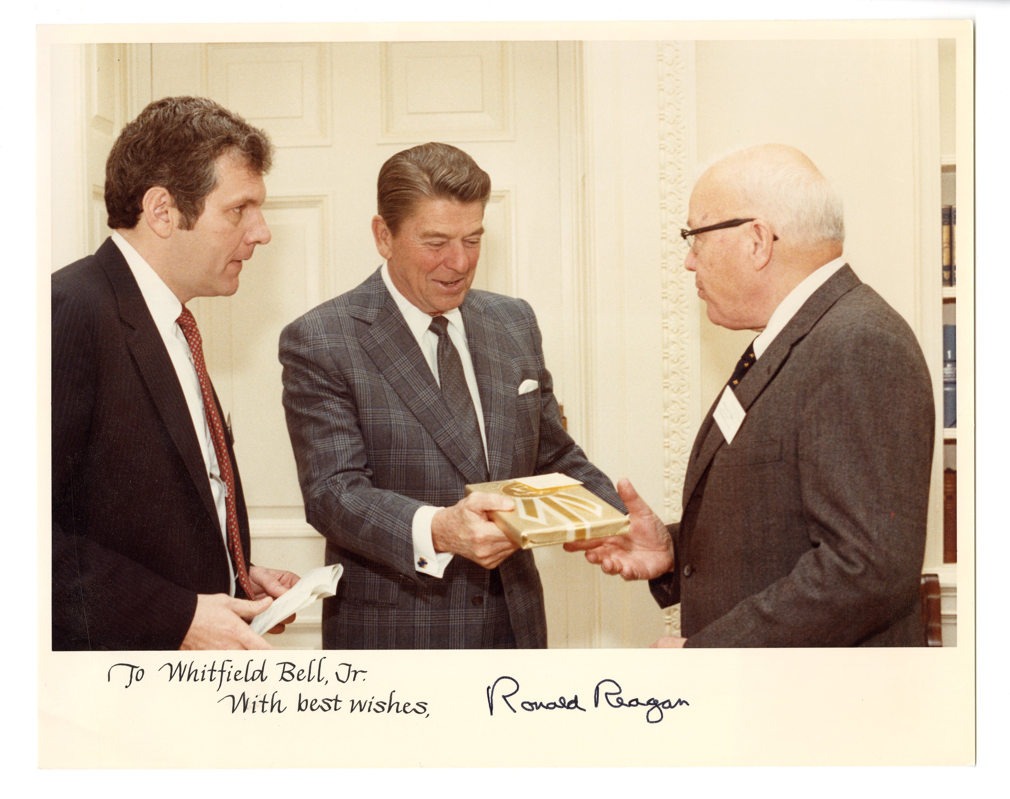 photo of Ronald Reagan and Whitfield Bell exchanging book