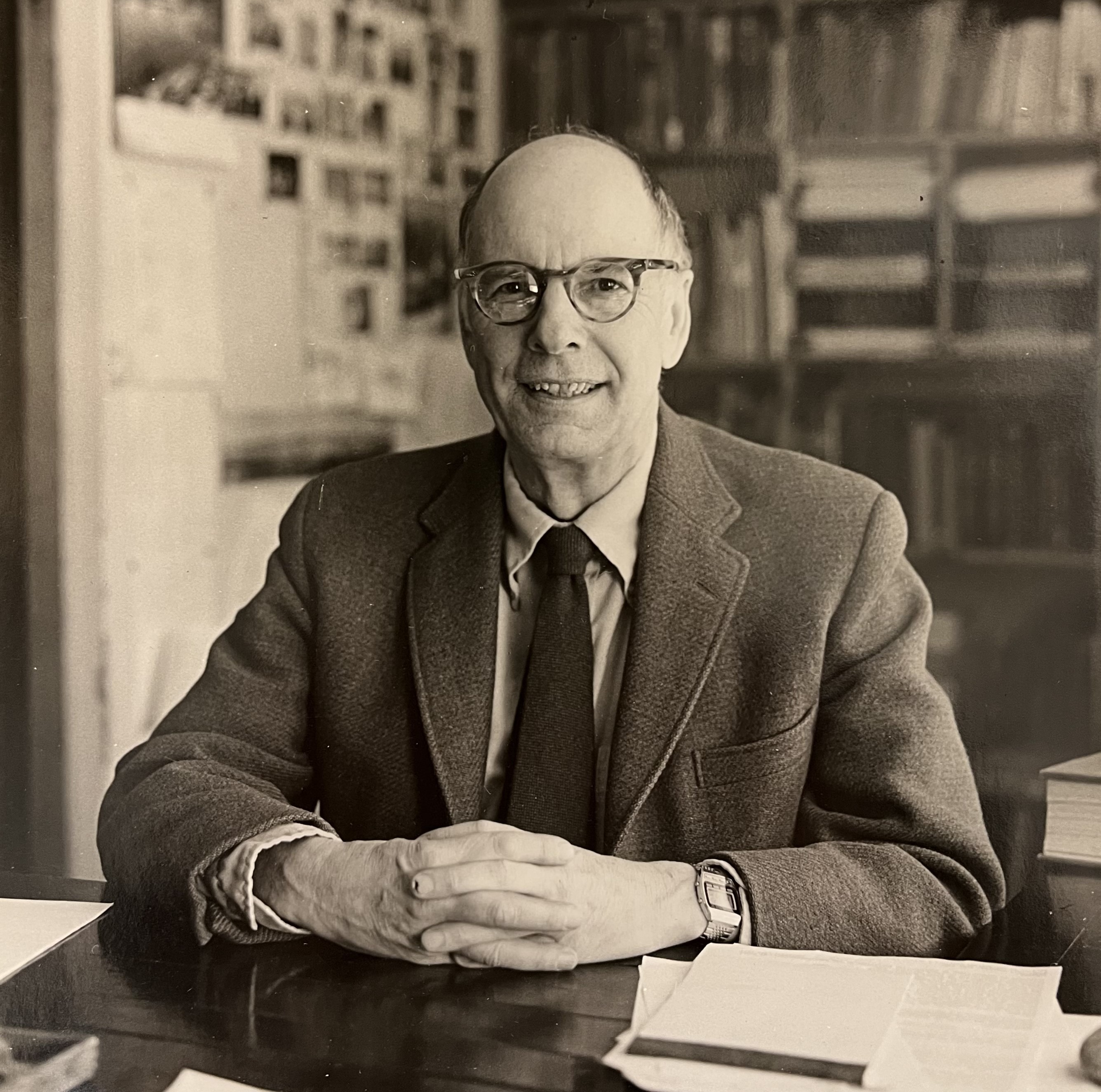 black and white photo of man seated at table