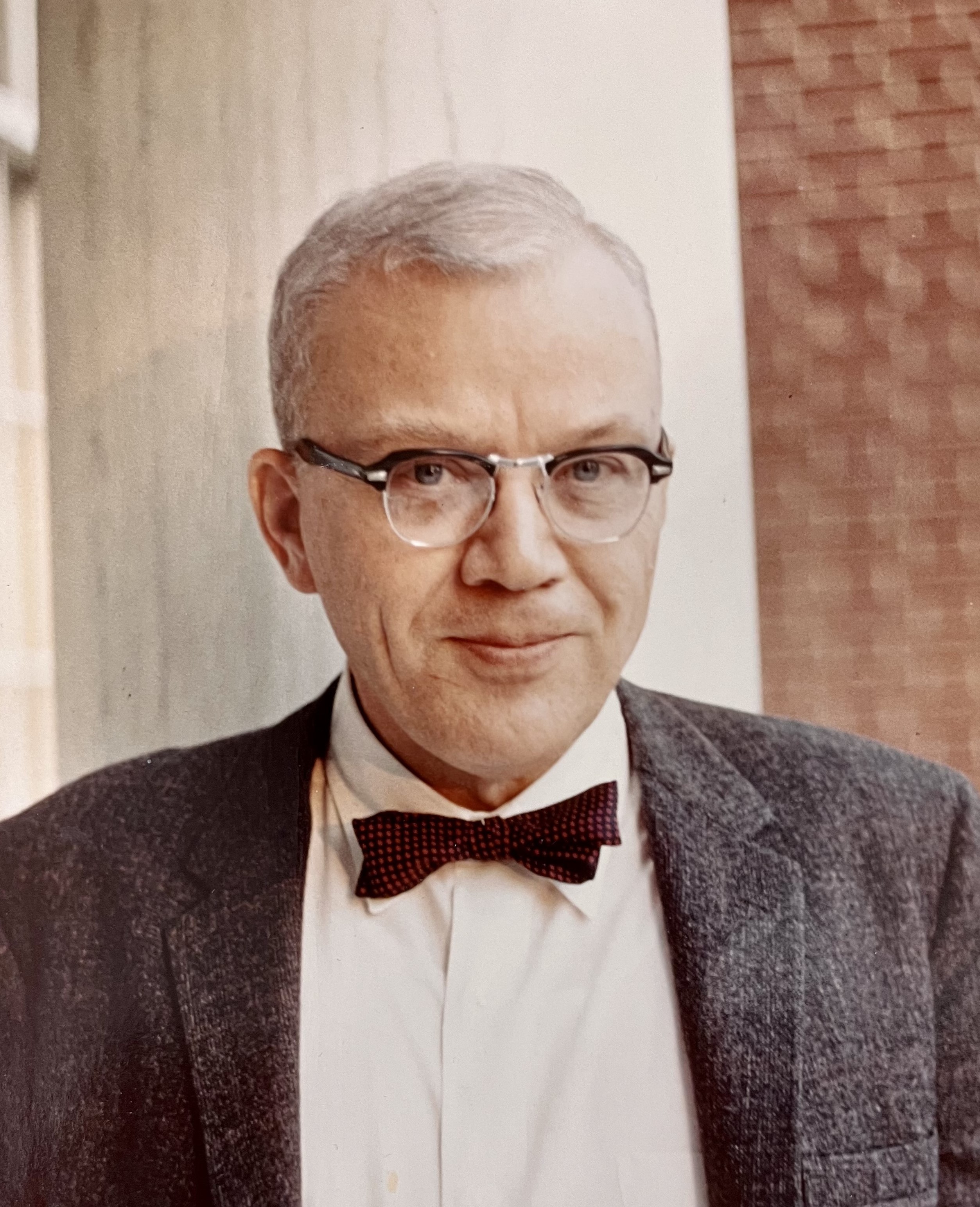 headshot photograph of man with glasses and bow tie