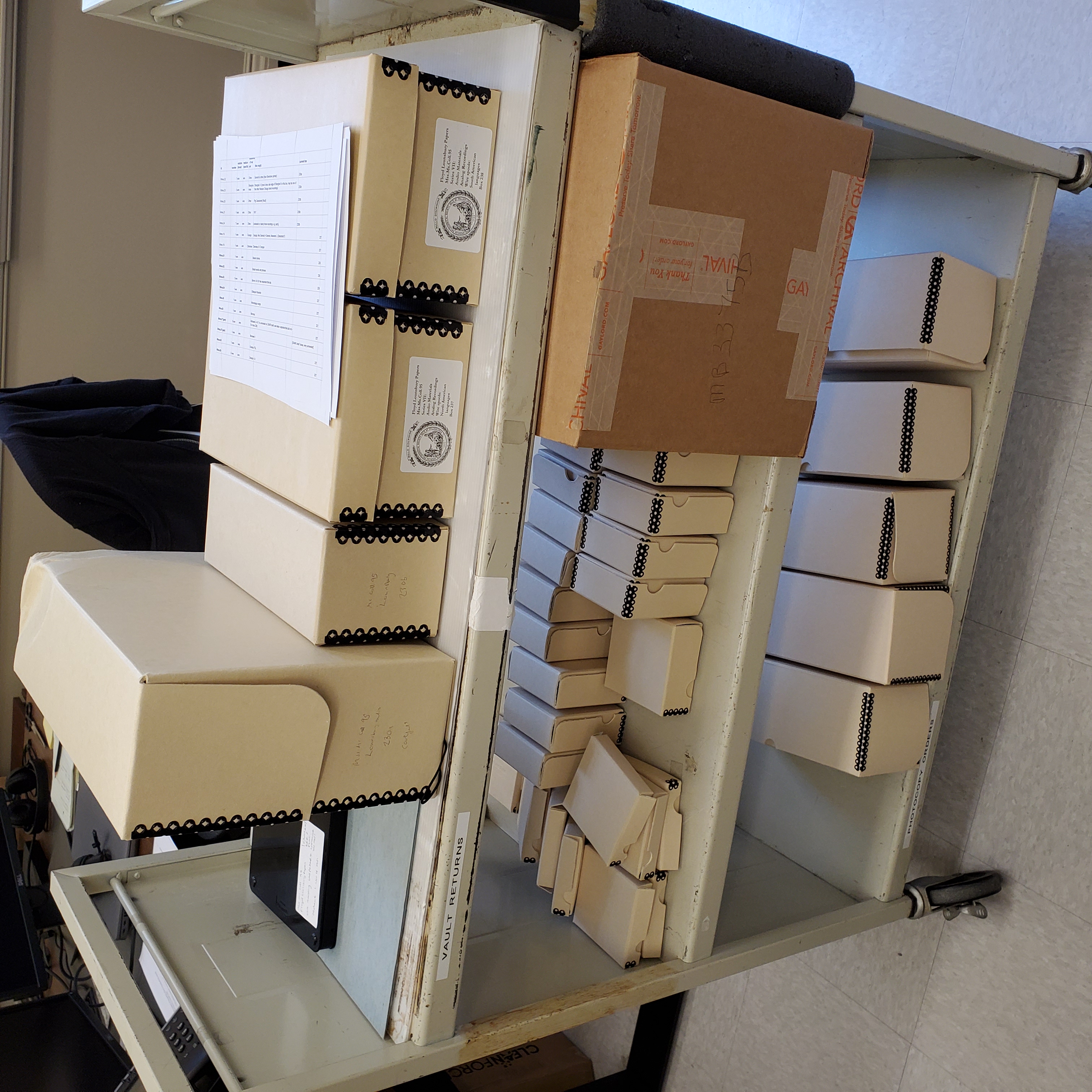 photo of boxes of supplies on a three-level library cart