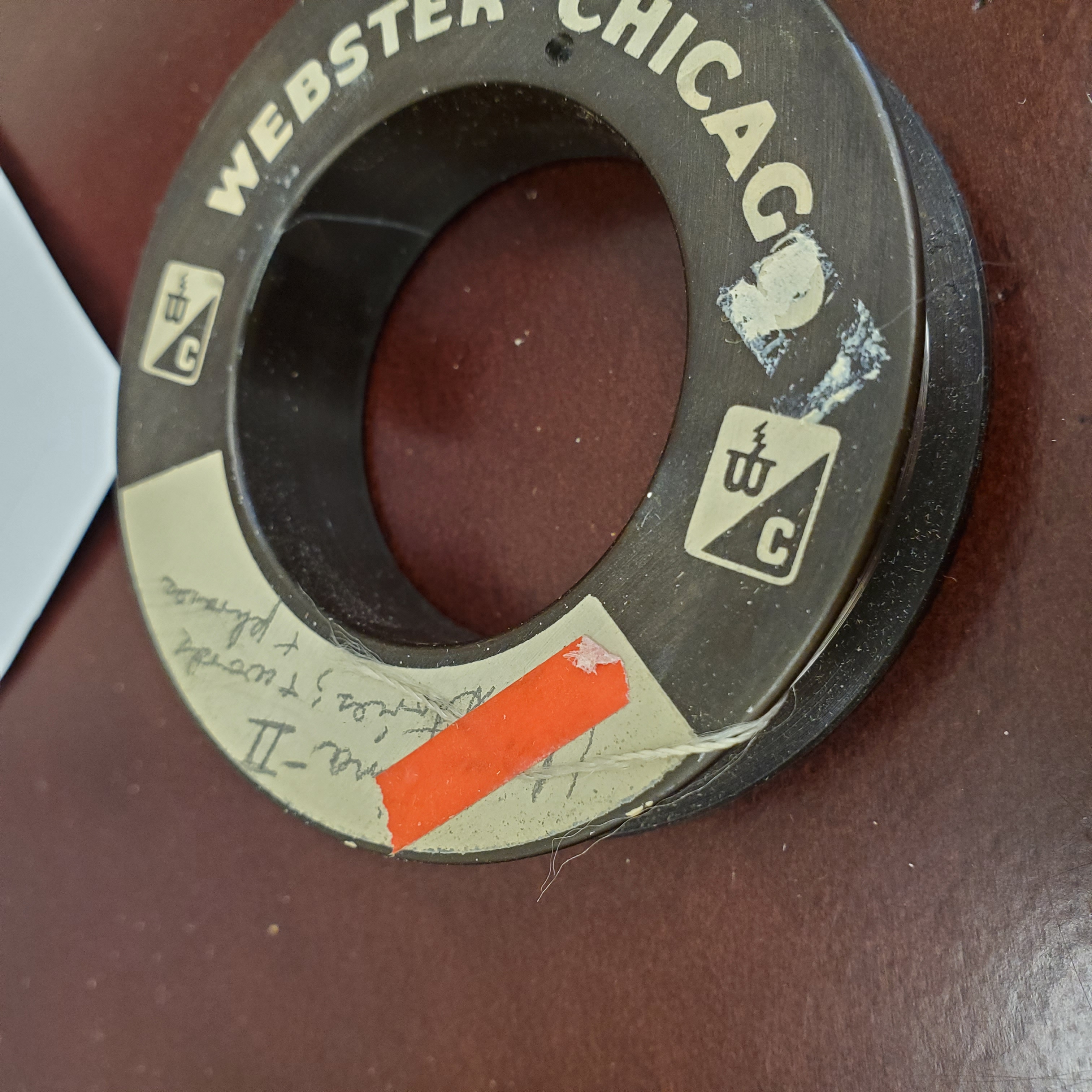 photo of a reel with a piece of orange tape securing the end of the wire