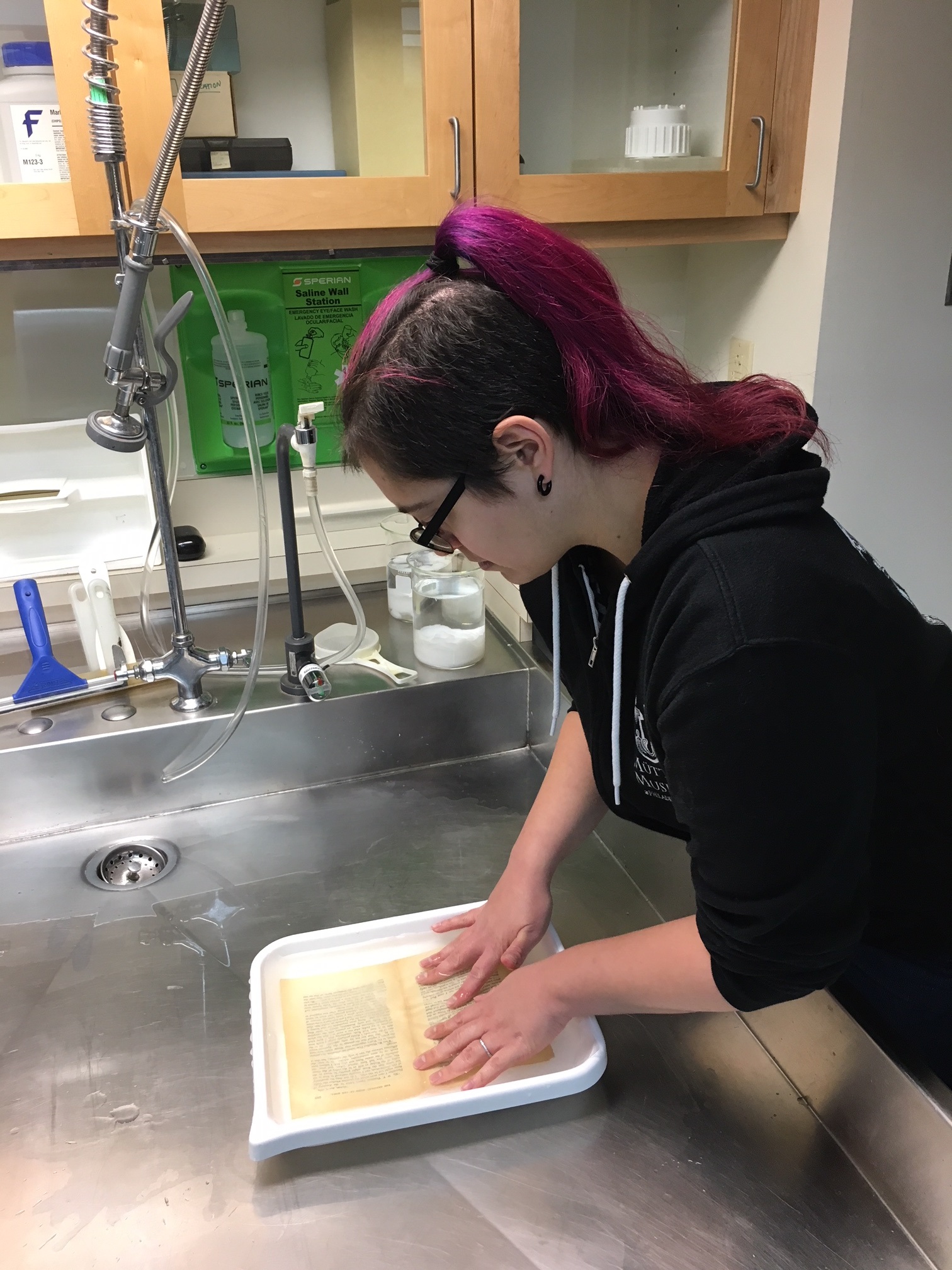 conservator submerges paper in water