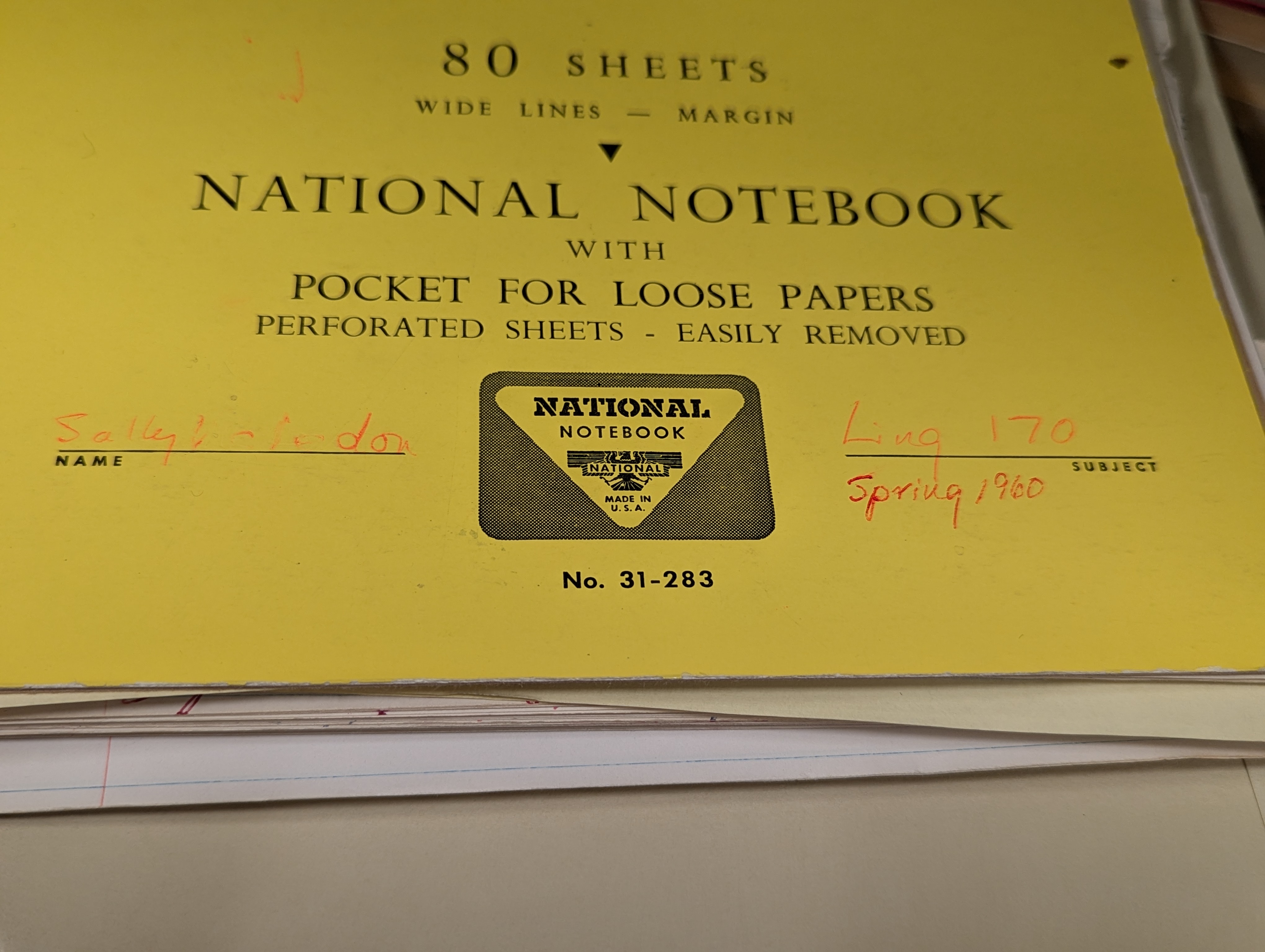 Photo of a bright yellow notebook cover, with sheets of paper poking out from underneath. In red ink ‘Sally McLendon’ is written on the line for “name” and ‘Ling 170, Spring 1960’ is written on the line for “subject”.
