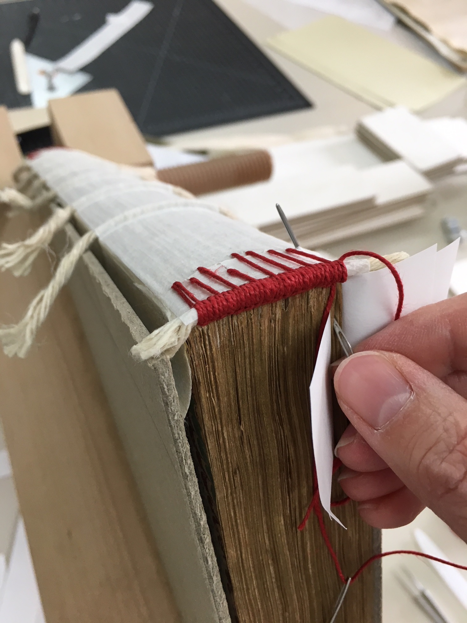 sewing end of book with red thread