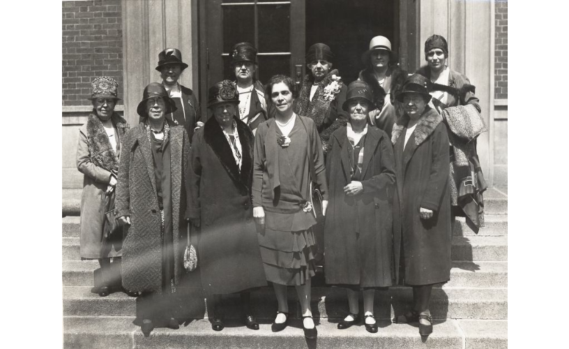 black and white photo of women standing on steps