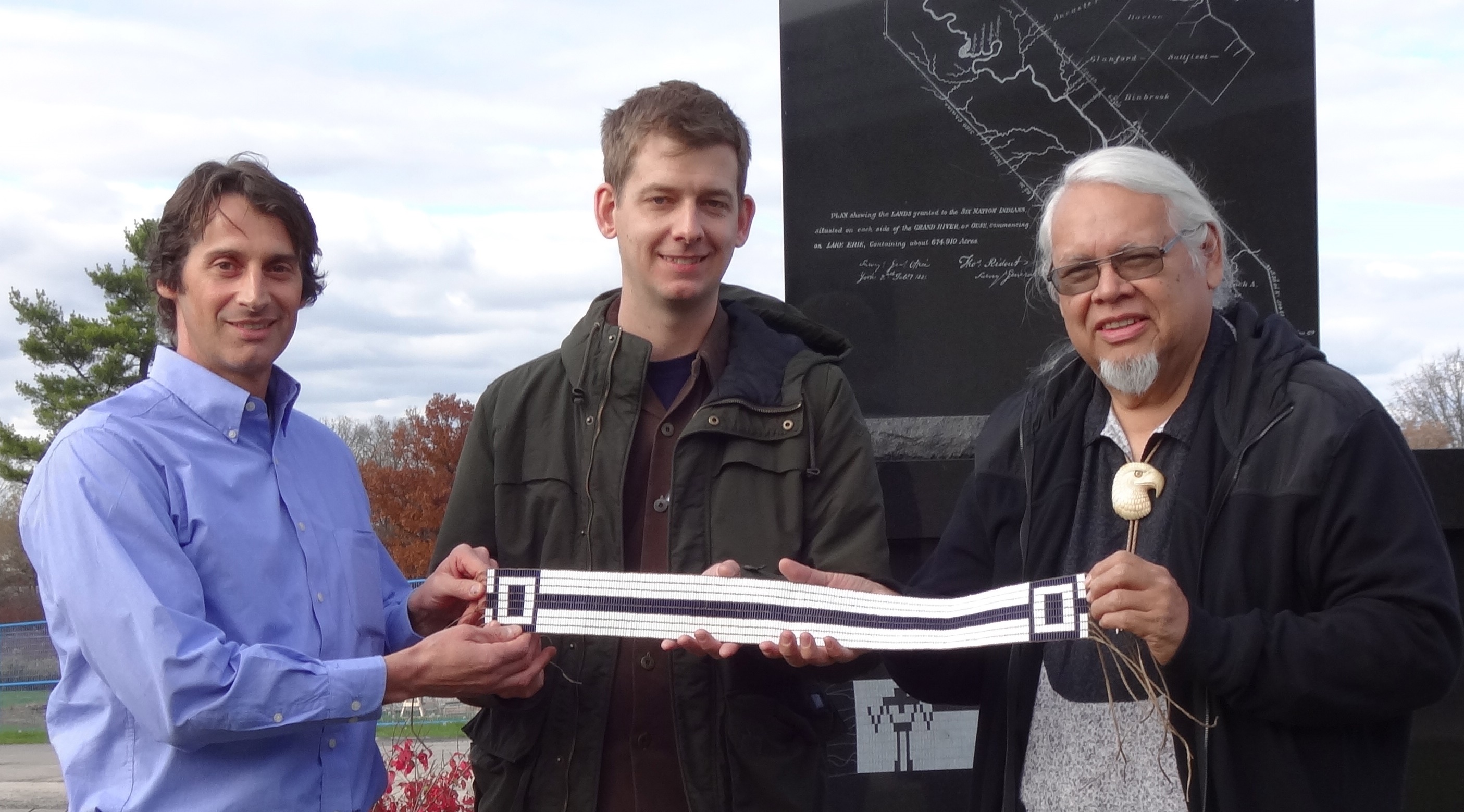 APS staff receiving wampum belt