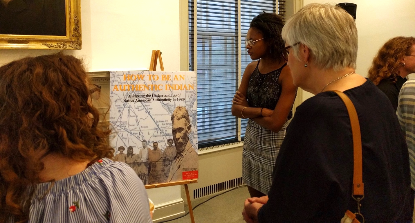 three women gathered around poster