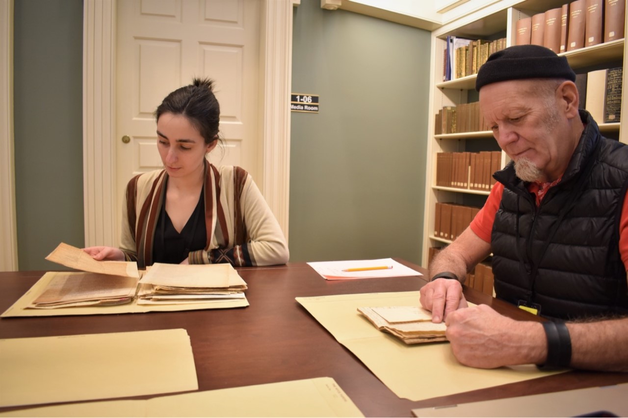 two people looking at documents in library