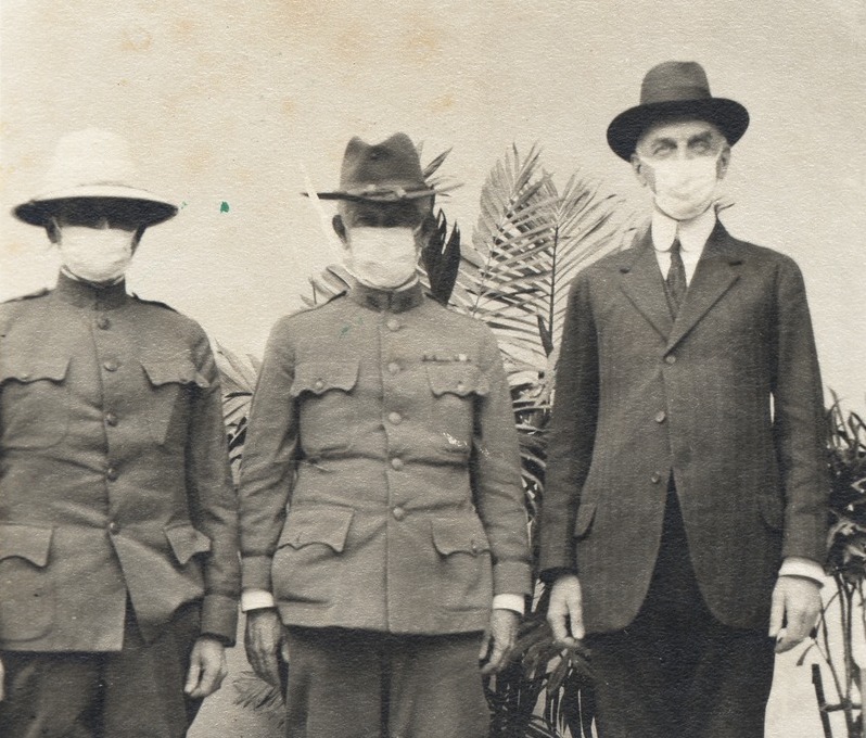 black and white photo of three men wearing surgical masks