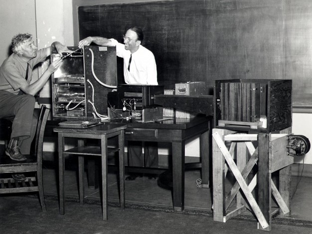 Two men work on scientific equipment