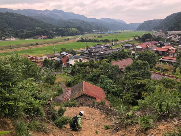 man crouched in landscape outside of Toyota Japan