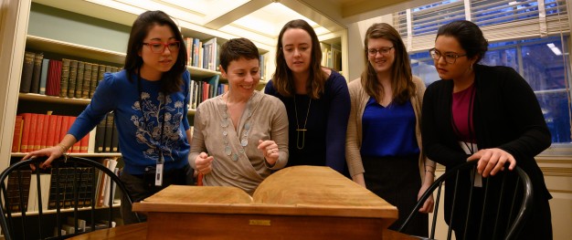 photo of 5 fellows looking at book