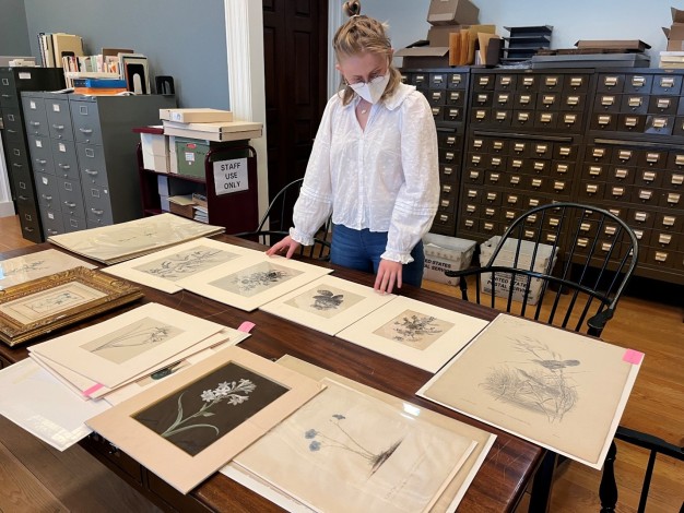 photo of Anna Guerrero in front of botanical images