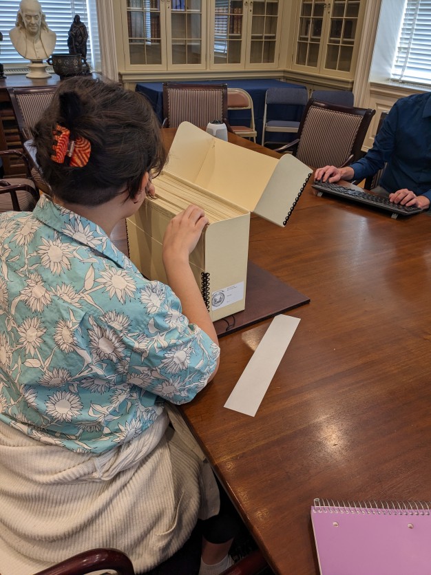 photo of woman seated looking through manuscript box