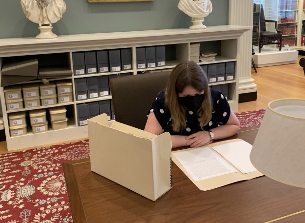 photo of woman seated at table with archival materials