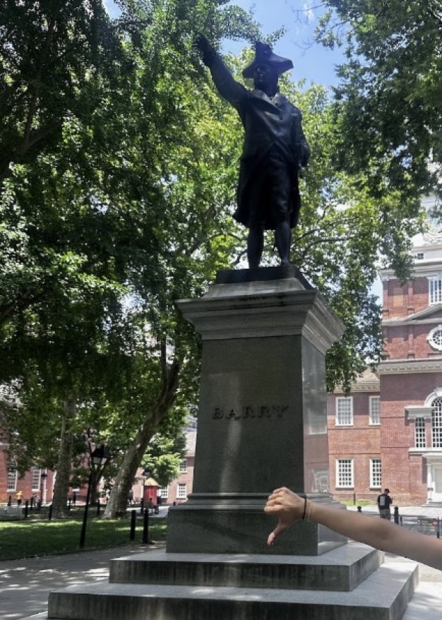 Foto de la estatua situada detrás del Independence Hall (Edificio de la independencia), con una mano haciendo un gesto de «pulgar hacia abajo» delante de ella