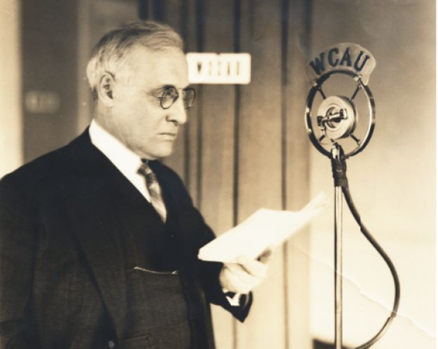 William E. Lingelbach standing in front of a radio microphone, ca. 1940s.