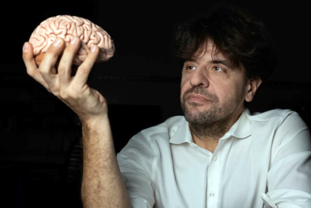Karl Deisseroth holding a brain in front of him.