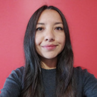 Selfie of a woman against a bright red background.