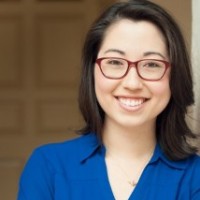 woman in blue blouse with red glasses