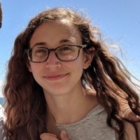 woman smiling with glasses and wavy hair