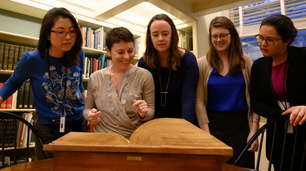 photo of 5 fellows looking at book