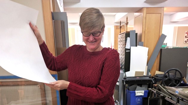 renee wolcott standing with documents being conserved