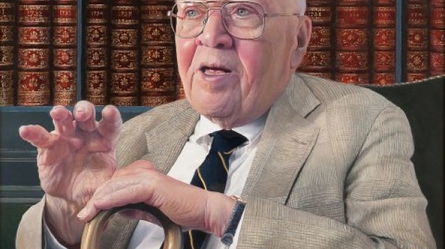 photo of Whitfield Bell seated in front of bookshelves
