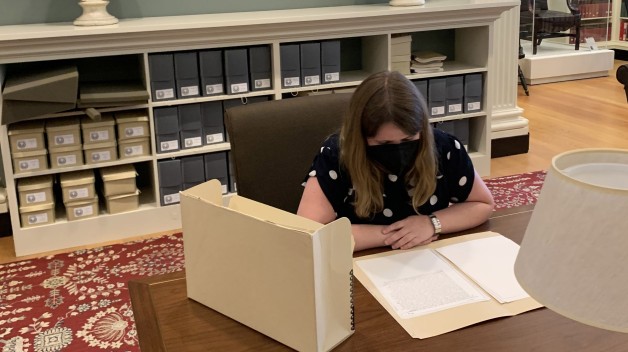 photo of woman seated at table with archival materials