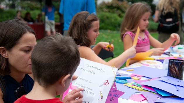 A picture of kids crafting paper stars at a table 