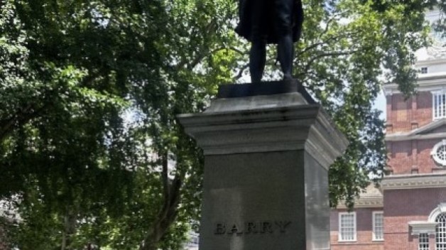 Foto de la estatua situada detrás del Independence Hall (Edificio de la independencia), con una mano haciendo un gesto de «pulgar hacia abajo» delante de ella