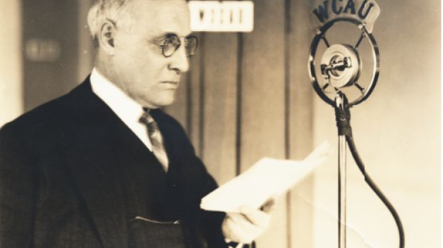 William E. Lingelbach standing in front of a radio microphone, ca. 1940s.