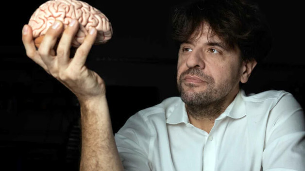 Karl Deisseroth holding a brain in front of him.