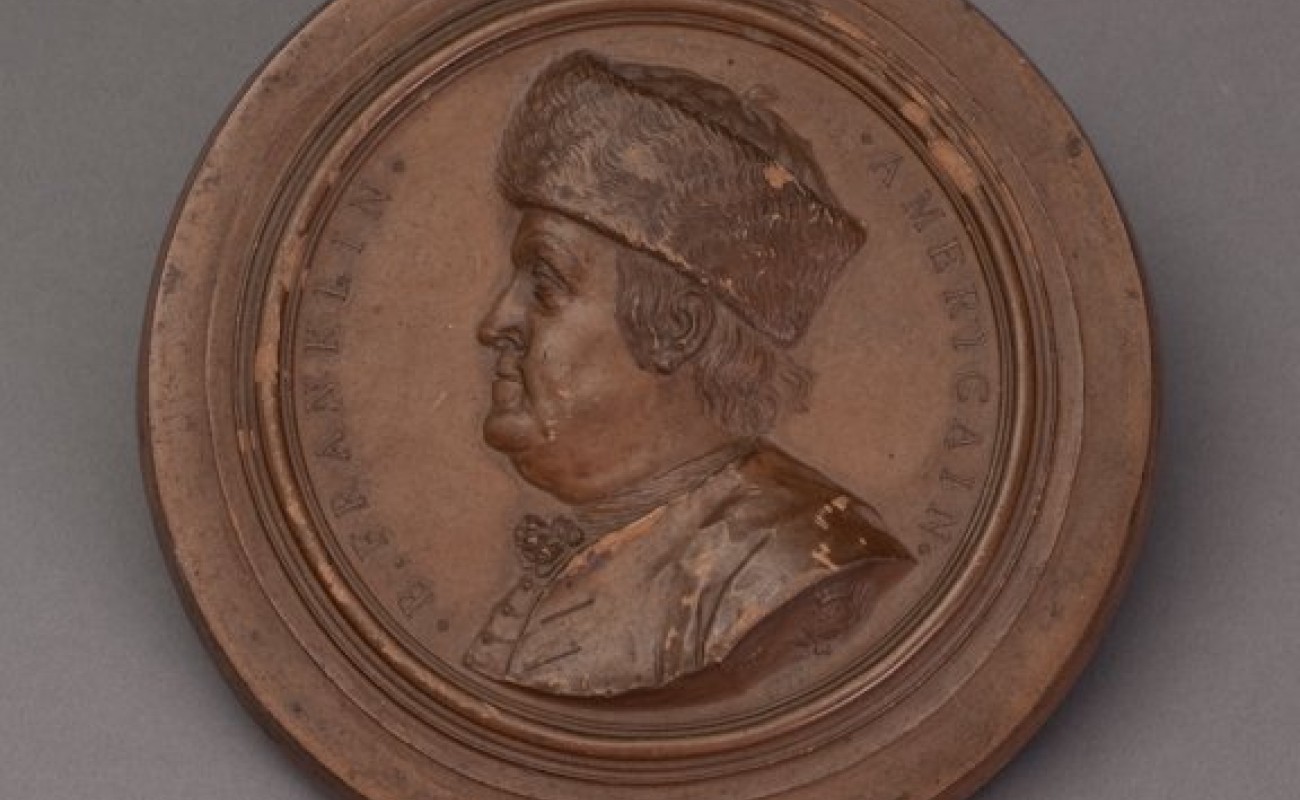 photo of a medallion with a profile portrait of Benjamin Franklin