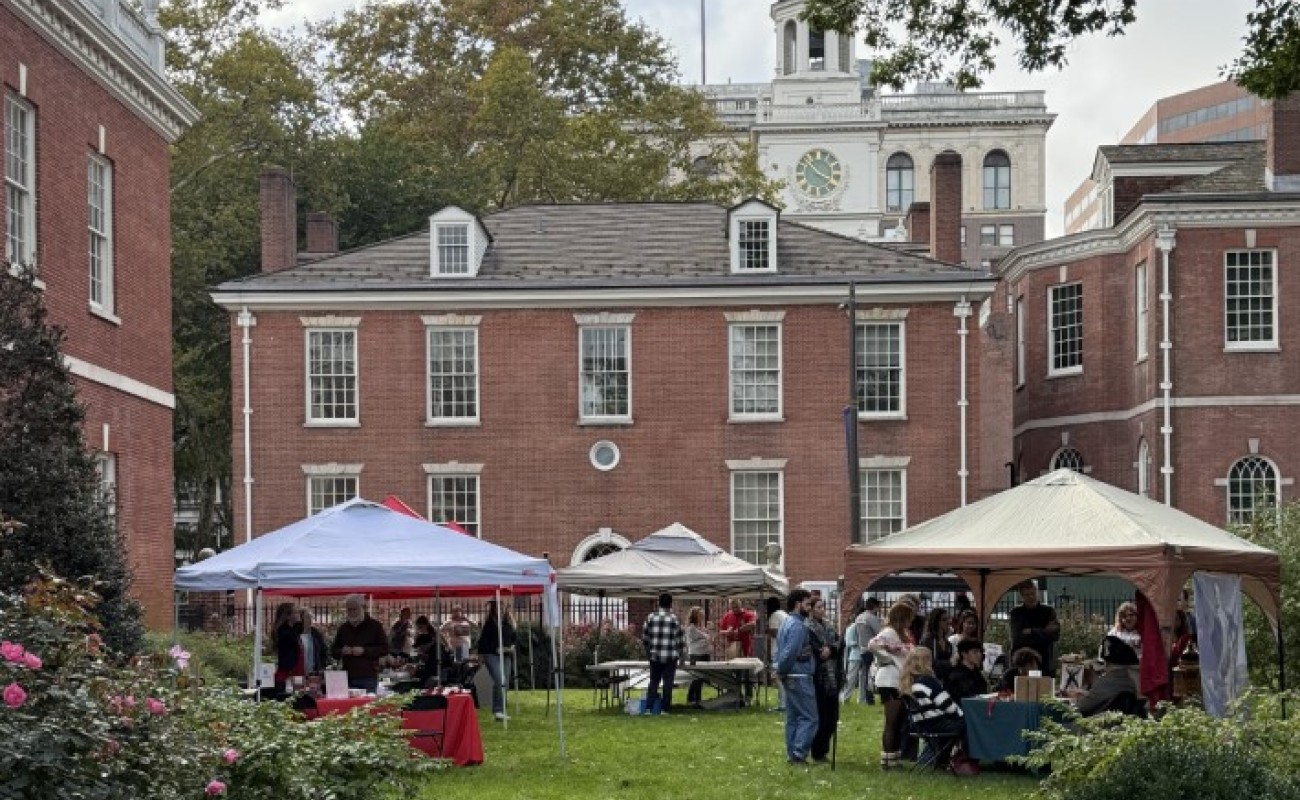 A picture of Jefferson Garden looking westward with Phil Hall in the background. The grounds have tents with people tabling in them and people doing the activities. 