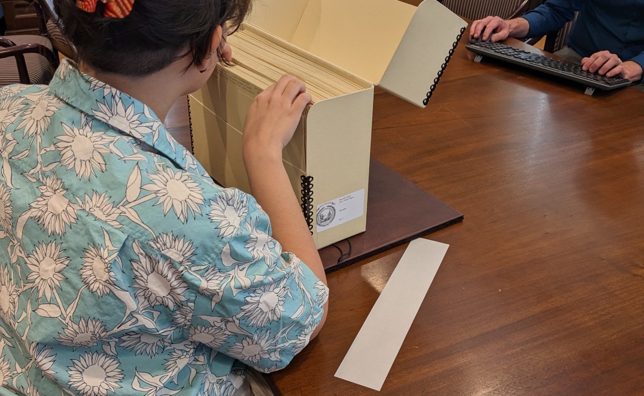 Mujer sentada revisando la caja de archivos