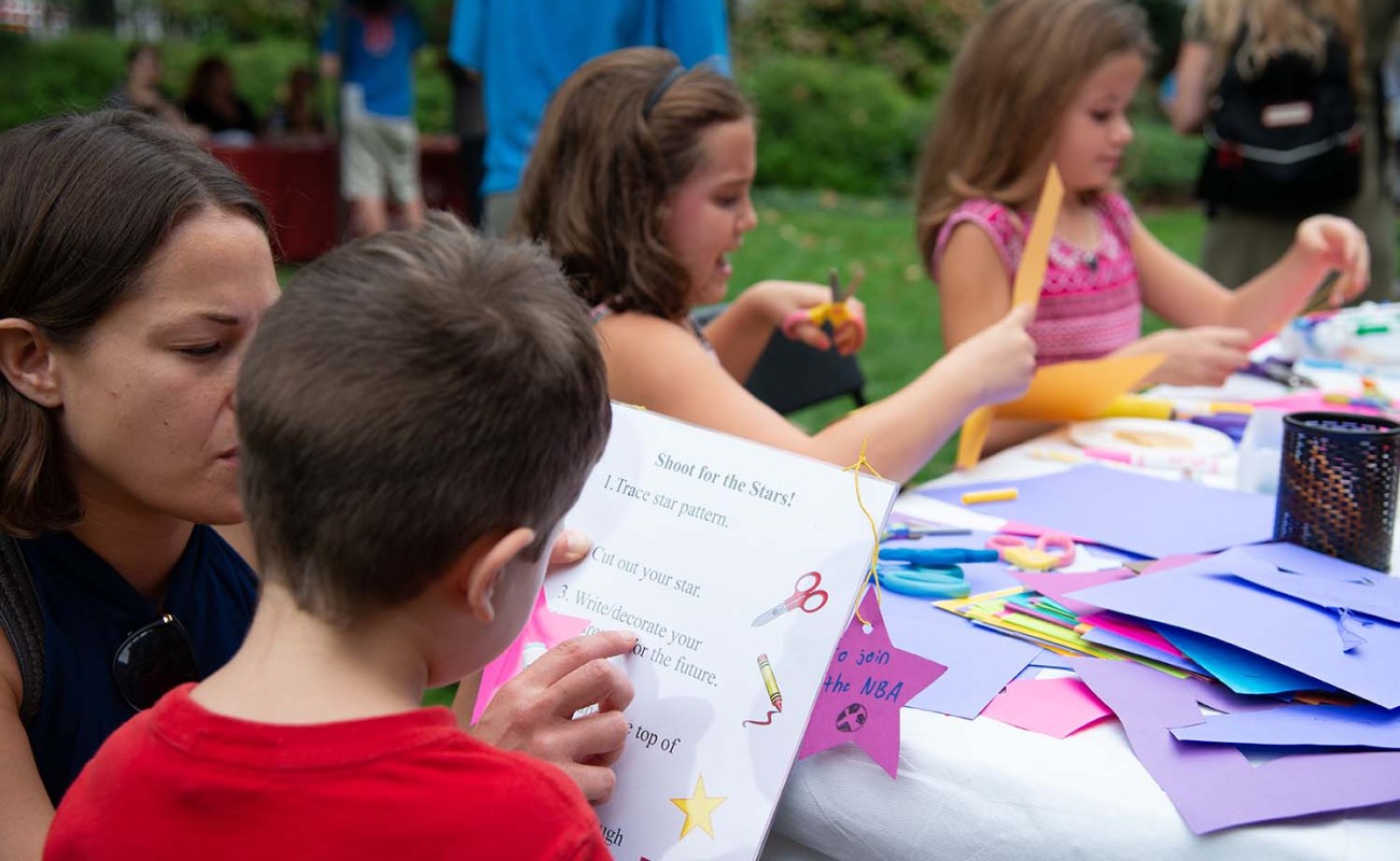 A picture of kids crafting paper stars at a table 