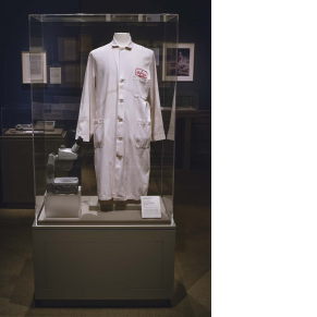 installation photograph of lab coat on mannequin with microscope beside it