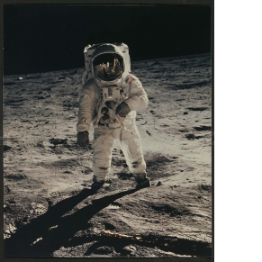 color photograph of man in spacesuit walking on the moon
