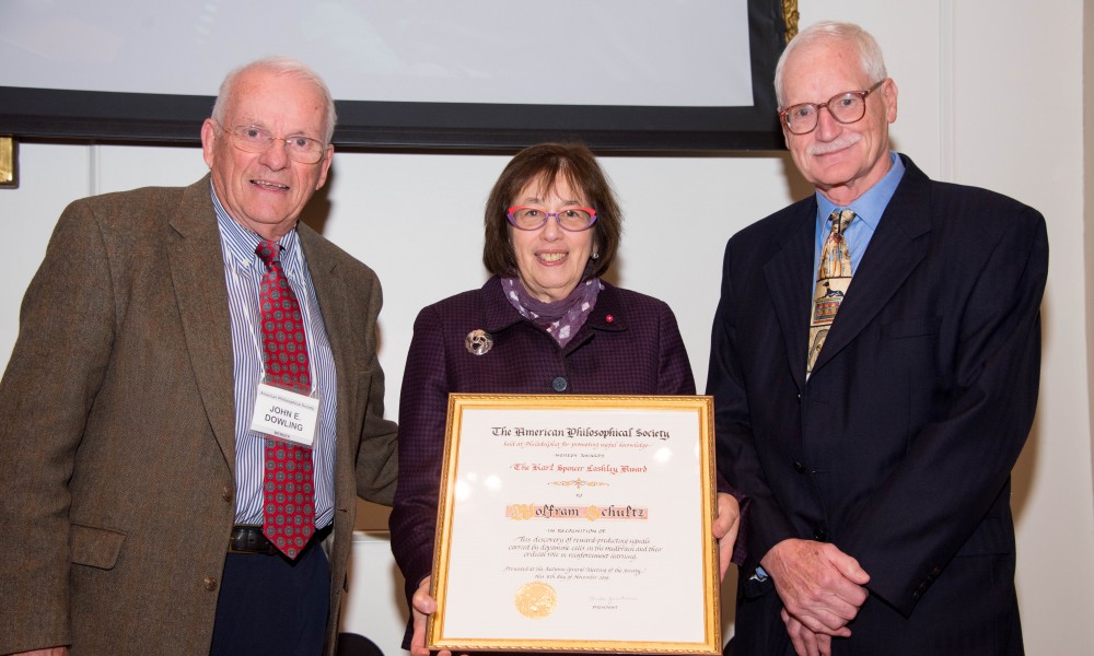 Linda Greenhouse Holds the Lashley Award certificate, standing between Wolfram Schultz and John Dowling