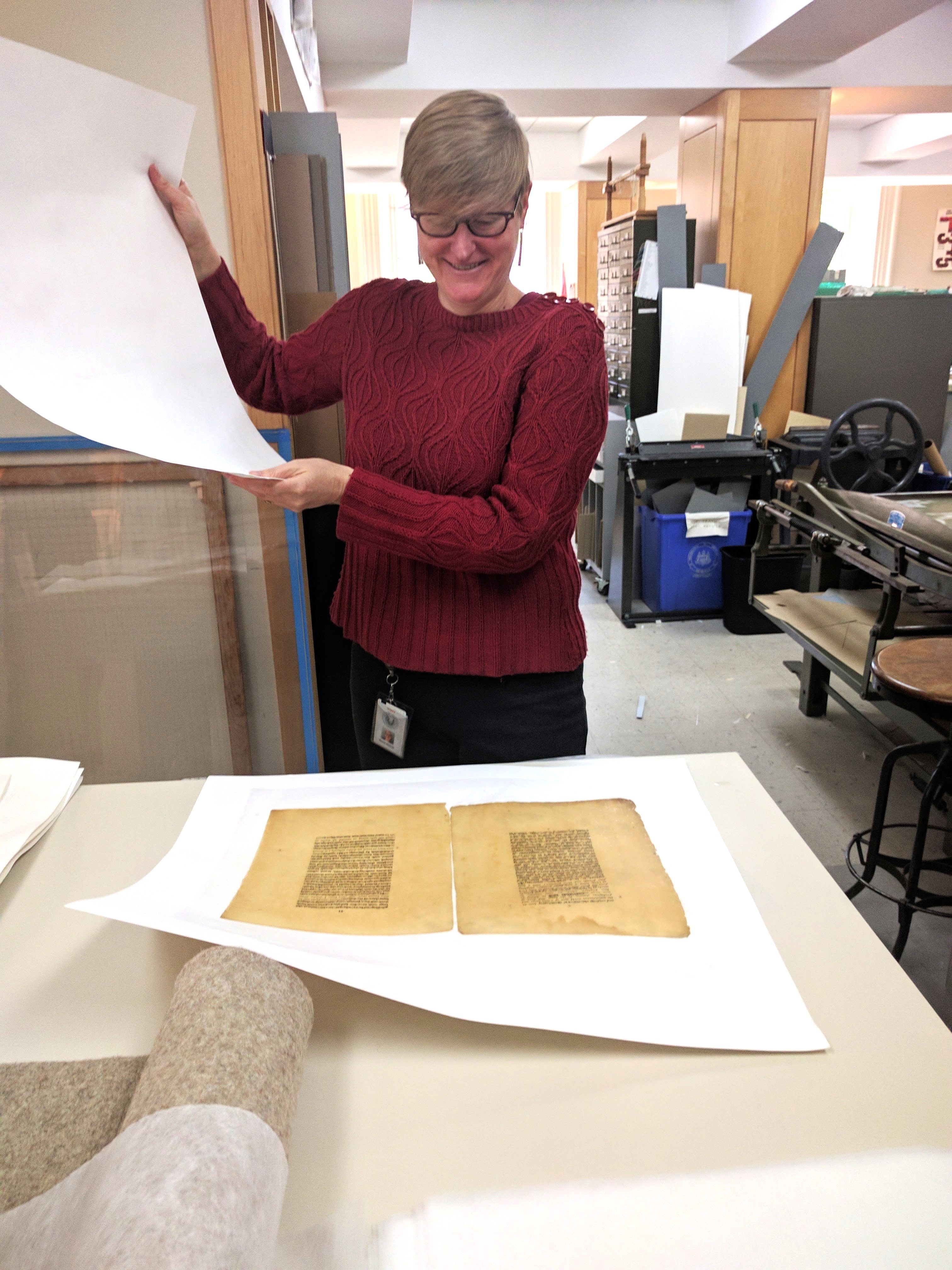 renee wolcott standing with documents being conserved
