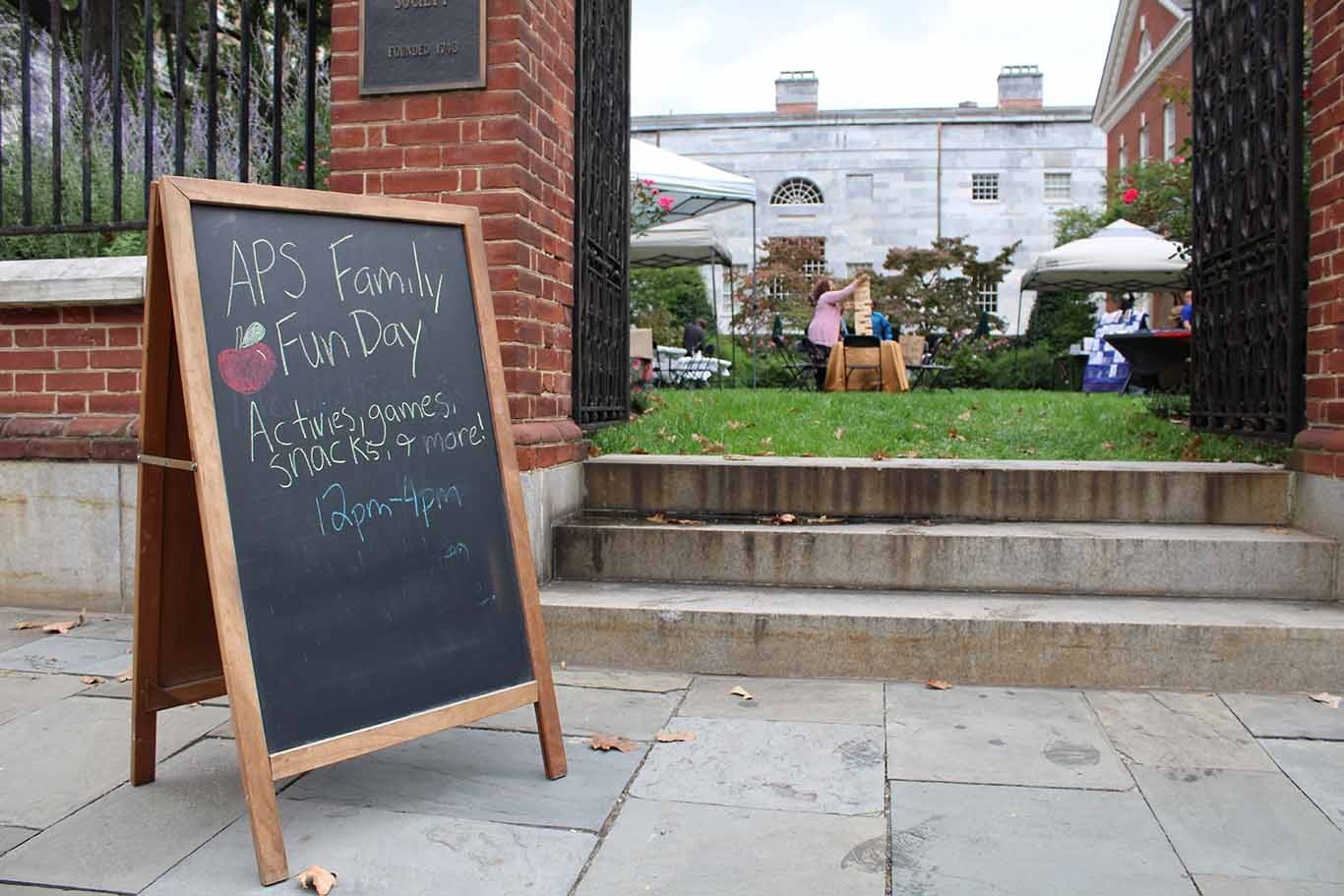 a picture of a chalk board on the left side with program information on it. A view in the middle of Jefferson Garden with people in it.
