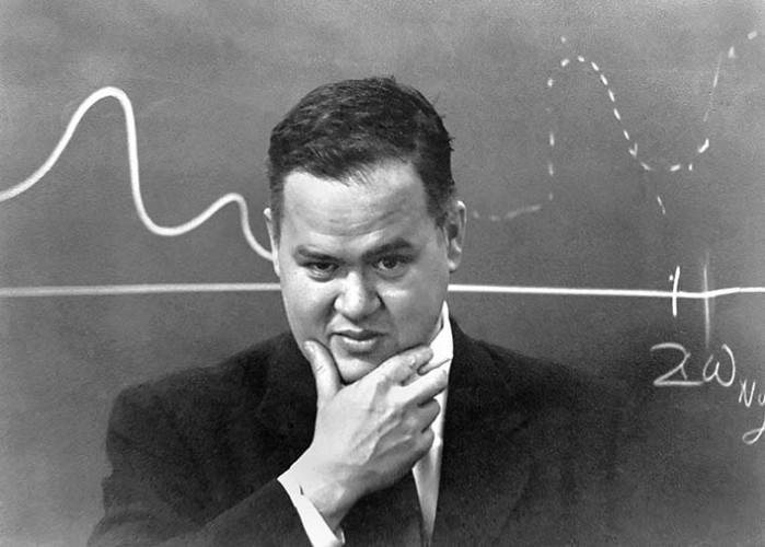 photograph of a man (John Tukey) in front of a blackboard