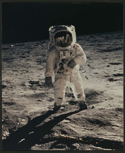 color photograph of man in spacesuit walking on the moon