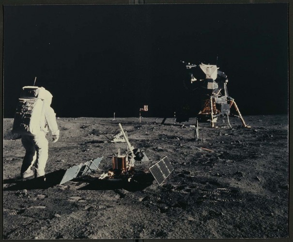 photograph of person wearing spacesuit walking on the moon with spaceship